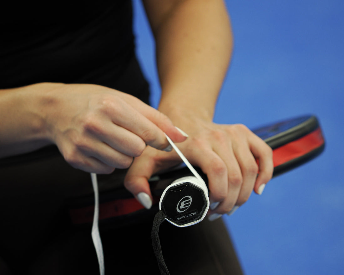 A racket has its overgrip rewrapped