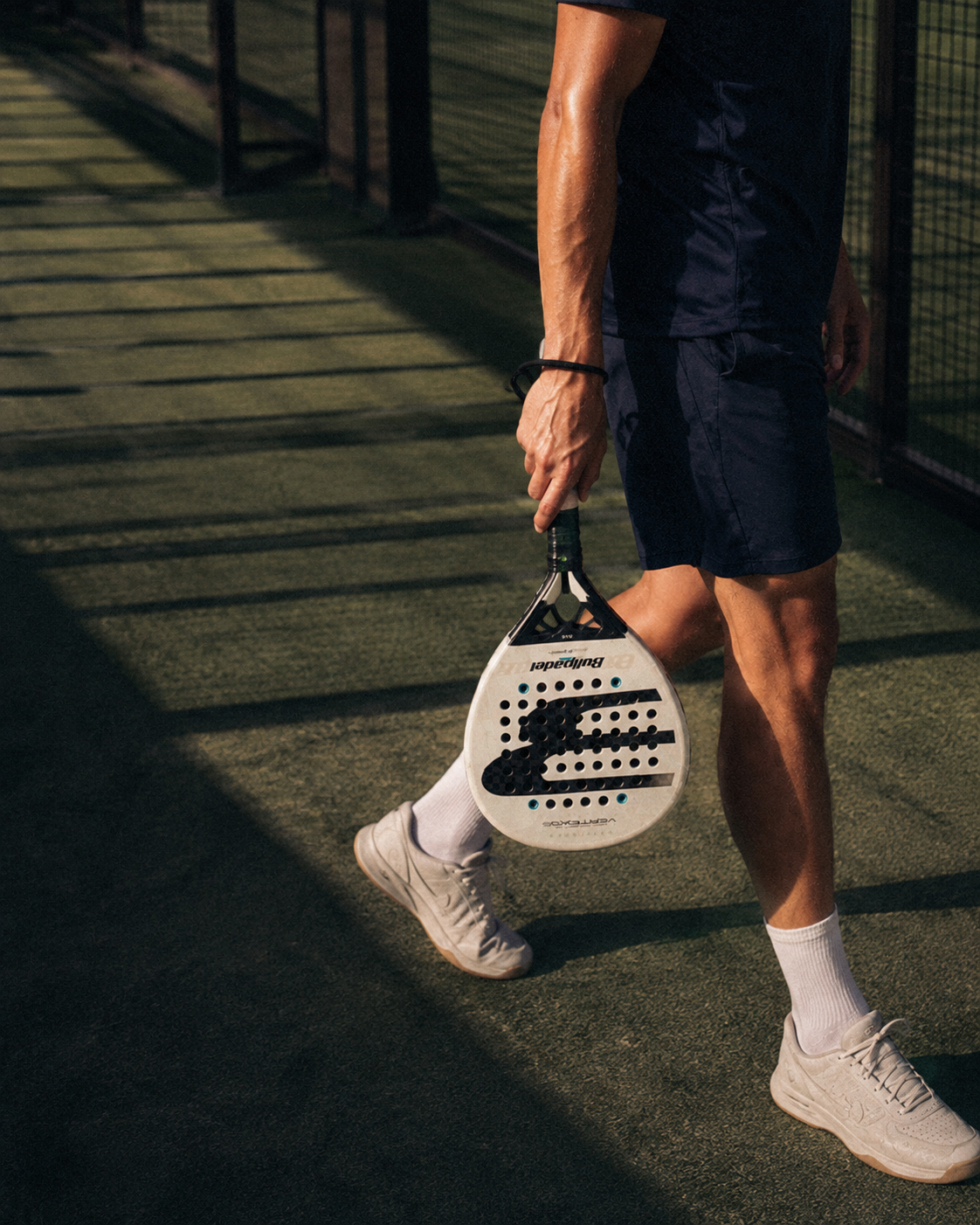 HEAD padel bag beside an outdoor court